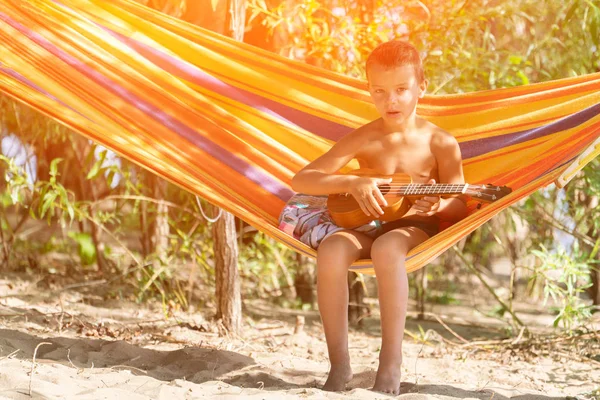 Junge Sitzt Hängematte Und Spielt Ukulele Strand — Stockfoto