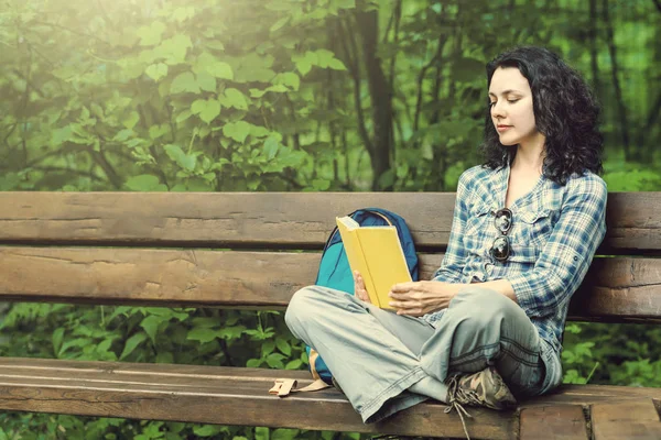 Traveling woman reading a book and relaxing at the park