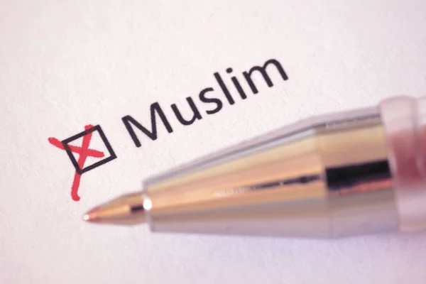 Questionnaire. Red pen and the inscription MUSLIM with cross on the white paper