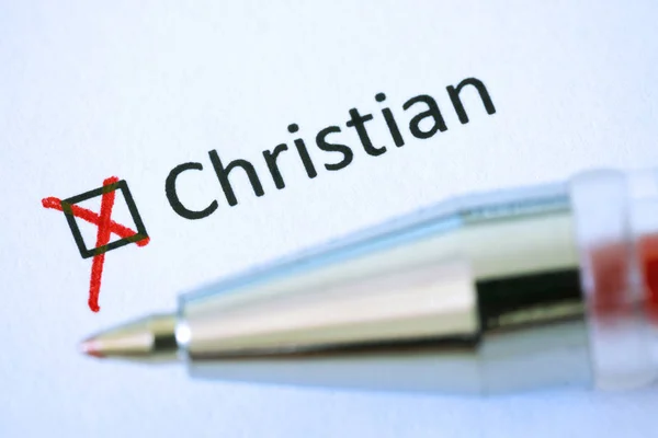 Questionnaire. Red pen and the inscription CHRISTIAN with cross on the white paper