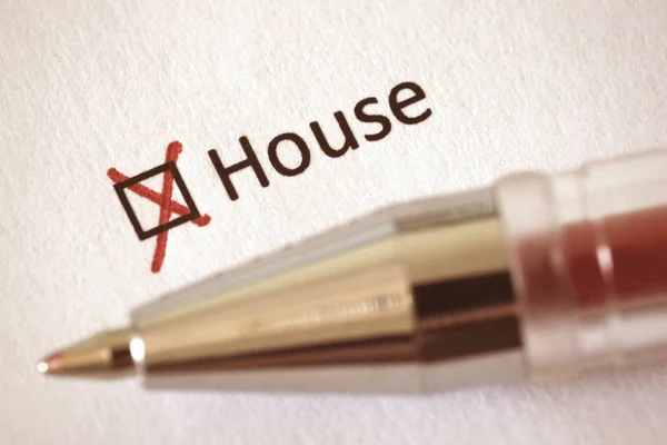 Questionnaire. Red pen and the inscription HOUSE with cross on the white paper