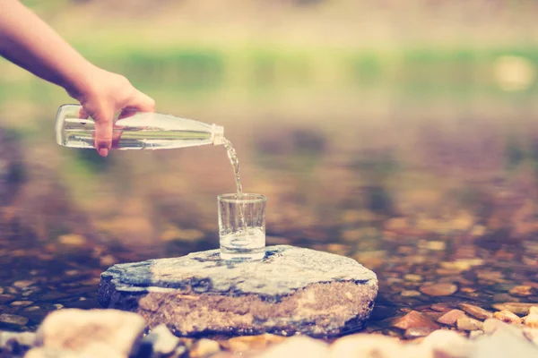 Выливание Очищенной Пресной Питьевой Воды Бутылки Стекло Фоне Природы — стоковое фото