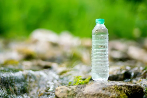 Plastic bottle with fresh cool water on nature background.
