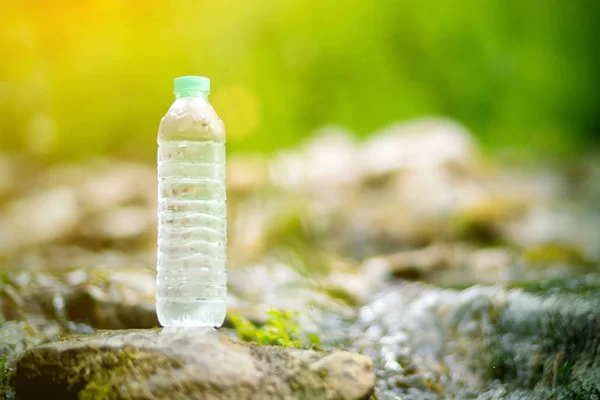 Plastic bottle with fresh cool water on nature background.