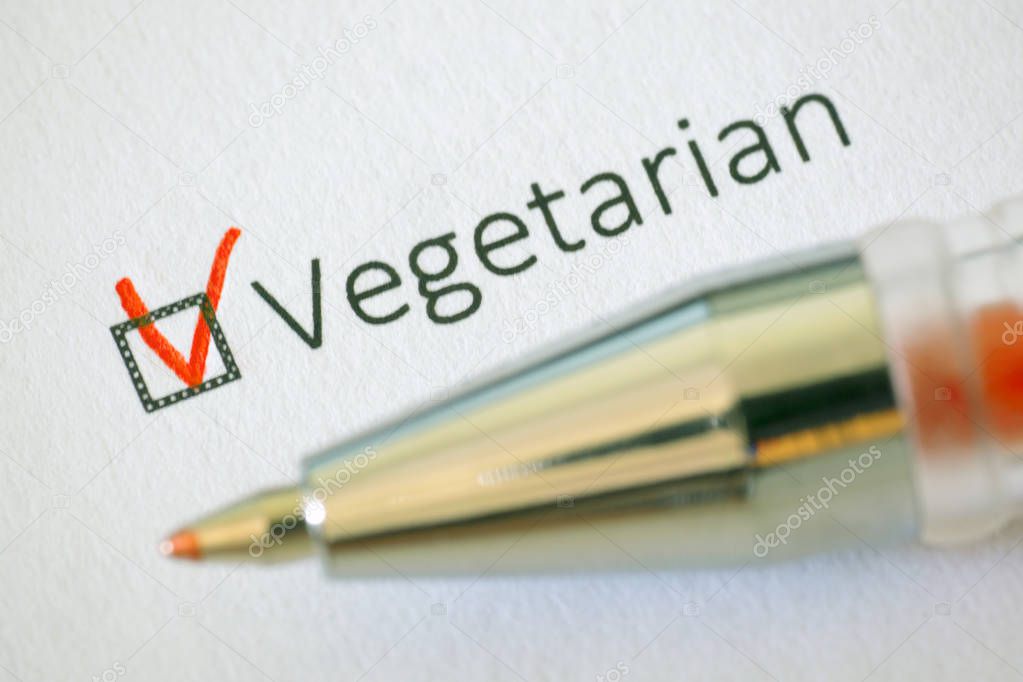Questionnaire. Red pen and the inscription VEGETARIAN with check mark on the white paper