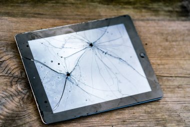 Ahşap masada kırık dokunmatik ekranlı Tablet Pc