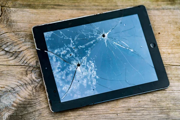 Tablet PC with broken touchscreen on the wooden table