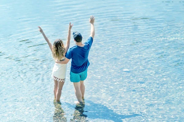 Счастливая Молодая Пара Обнимается Машет Руками Пляже — стоковое фото