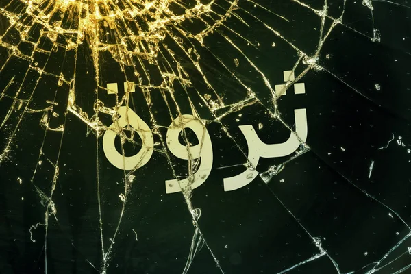 Arabian text "Wealth" on the broken glass. — Stock Photo, Image