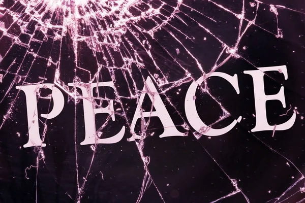 Text "Peace" on the broken glass. — Stock Photo, Image