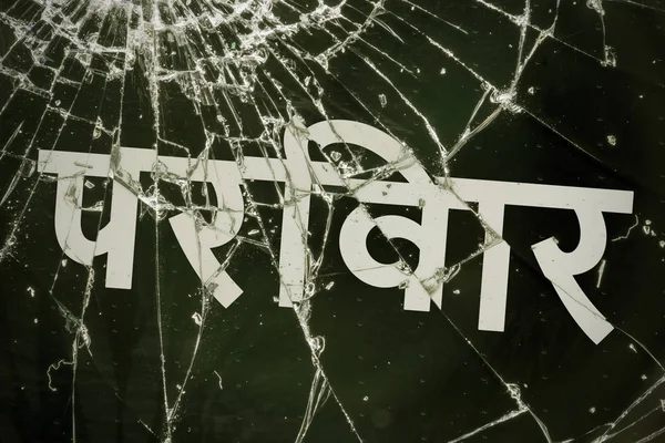 Текст на хинди "Семья" на разбитом стекле . — стоковое фото