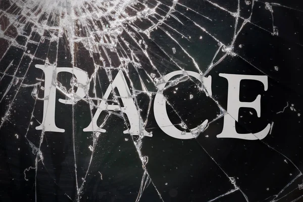 Der italienische Text "Frieden" auf dem zerbrochenen Glas. — Stockfoto
