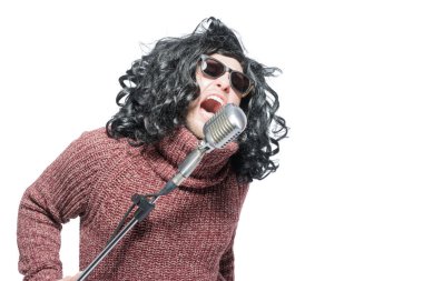 Bir mikrofon ile bir peruk ve güneş gözlüğü duygusal şarkı adam