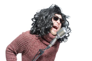 Peruklü etkileyici bir adam mikrofona şarkı söyledi..