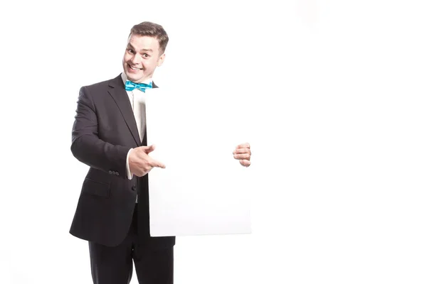 L'uomo divertente in giacca e cravatta si mostra su un foglio bianco. Su uno sfondo bianco — Foto Stock