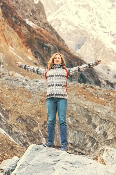 Блондинка в пиджаке, стоящая с поднятыми в горах руками — стоковое фото
