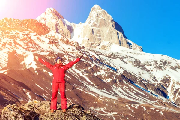 Usměvavá žena v červeném kabátku s rukama nahoře v horách na — Stock fotografie
