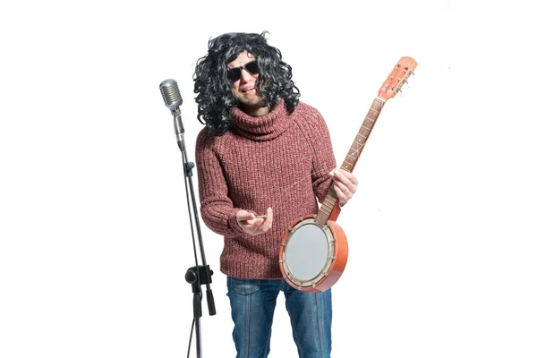 Smutny człowiek w peruce z banjo na mikrofon. — Zdjęcie stockowe