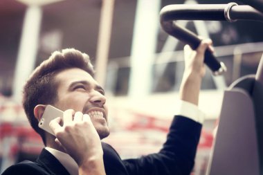 Beyaz gömlekli ve takım elbiseli, telefonu olan genç bir adam