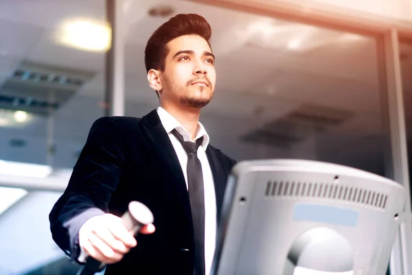 The guy in the white shirt and suit on the treadmill in the gym — Stock Photo, Image