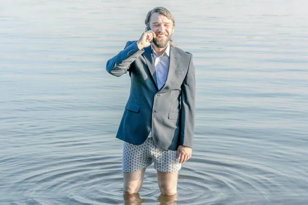 재킷과 속옷을 입고 웃고있는 남자가 물 속 깊은 — 스톡 사진