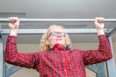 Gözlüklü ve kırmızı gömlekli komik adam spor salonunda ortaya çıkıyor..