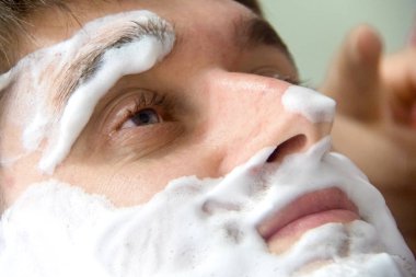 Yüzünde tıraş köpük ile genç adam.