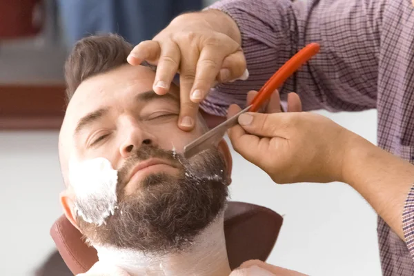 Парикмахерская. Делать бороду для человека с ирокезом . — стоковое фото