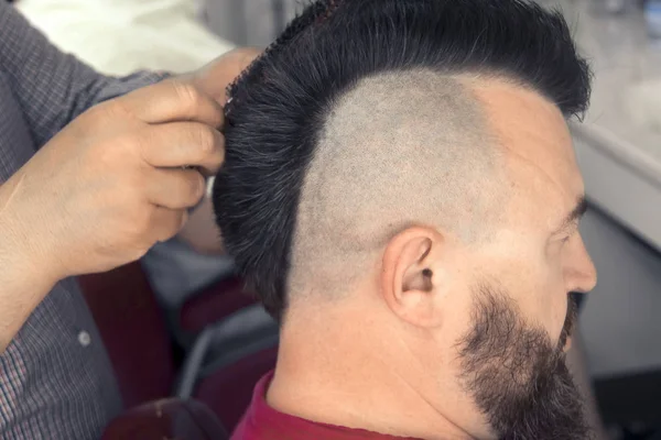 Barbershop. The master makes a man a mohawk — Stock Photo, Image
