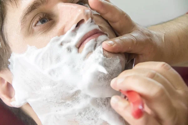 Baard scheren. Jonge man bij de kapper. — Stockfoto