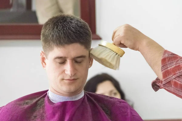 Jonge man bij de kapper. Afwerking kapsels. — Stockfoto