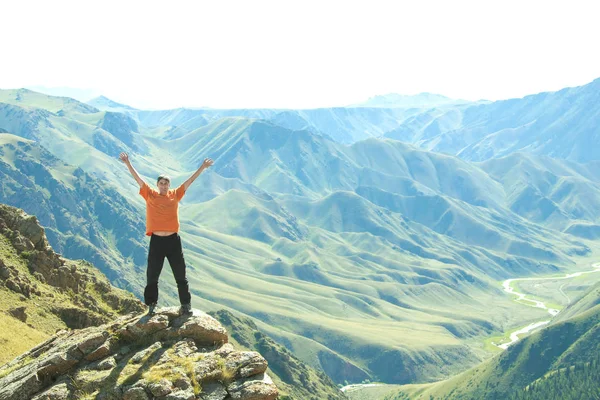 Lächelnder Mann mit erhobenen Armen auf einem der Berge. — Stockfoto