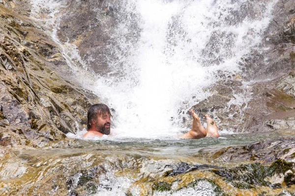 Glücklicher Mann schwimmt im Gebirgsfluss. — Stockfoto