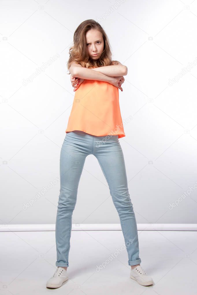 Offended girl with arms crossed on her chest in full growth on a