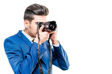 Beyaz bir bac bir kamera ile mavi takım elbiseli genç çekici adam