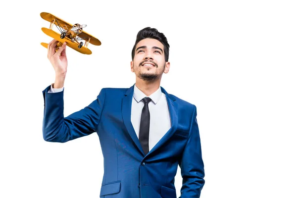 A smiling young man in a suit holds a model airplane on a light — Stock Photo, Image