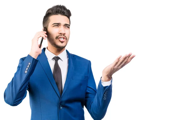 Молодий бізнесмен в синьому костюмі говорить по телефону в студії — стокове фото