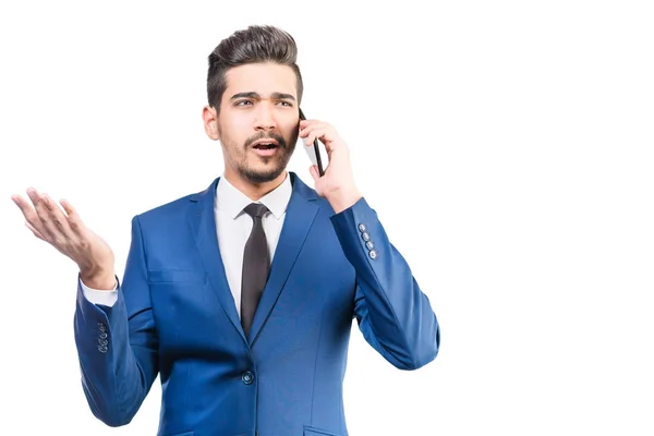 Attractive man in a blue suit talking by the phone on a white b — Stock Photo, Image