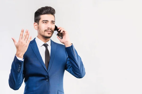 Attractive man in a blue suit talking on the phone in the studio — Stock Photo, Image