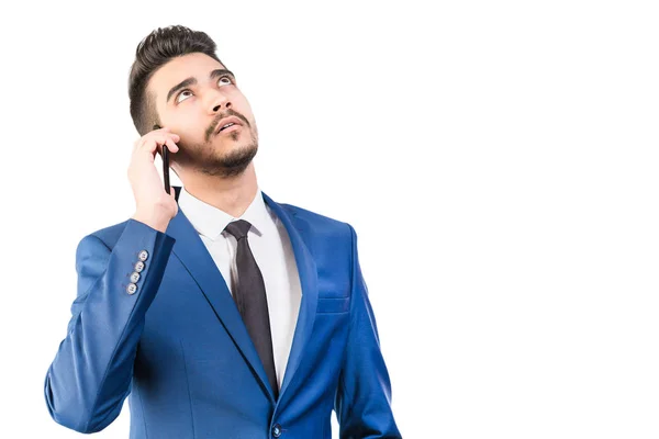 A young man in a blue suit talking on the phone in the studio on — Stock Photo, Image