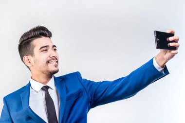 Mavi takım elbiseli gülümseyen bir işadamı hafif bir b selfie yapar