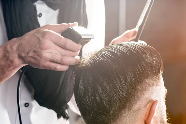 Barbershop. Professional maakt kapsel een man met een baard . — Stockfoto