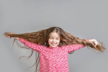 Kırmızı elbiseli gülen kız farklı direc uzun saç çekerek