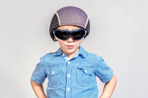 Gözlüklü komik çocuk ve gri bir arka plan üzerinde bir şapka. — Stok fotoğraf