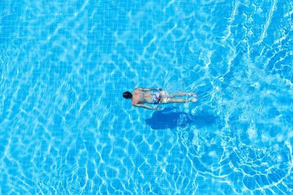Draufsicht eines Mannes, der in einem Pool unter Wasser schwimmt. — Stockfoto