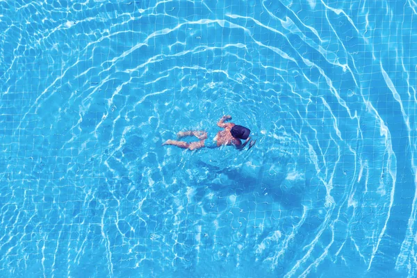 Top view of a swimming girl in the hotel pool. — Stock Photo, Image