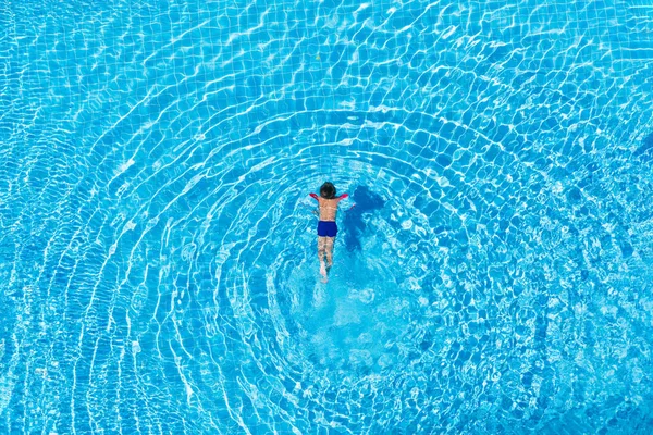 Vista dall'alto di un ragazzo che nuota in una piscina all'aperto . — Foto Stock