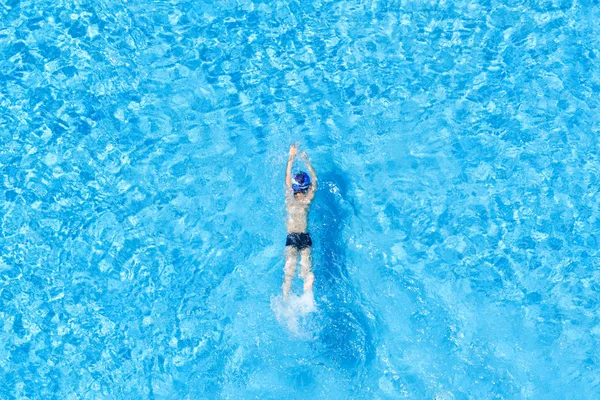 Blick von oben auf einen Jungen, der in einem Freibad schwimmt. — Stockfoto