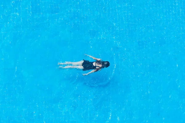 The girl swims under water in the pool, top view. — Stock Photo, Image