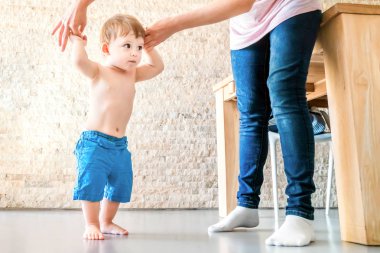 Sevimli bebek annenin yardımıyla yürümeyi öğrenir.